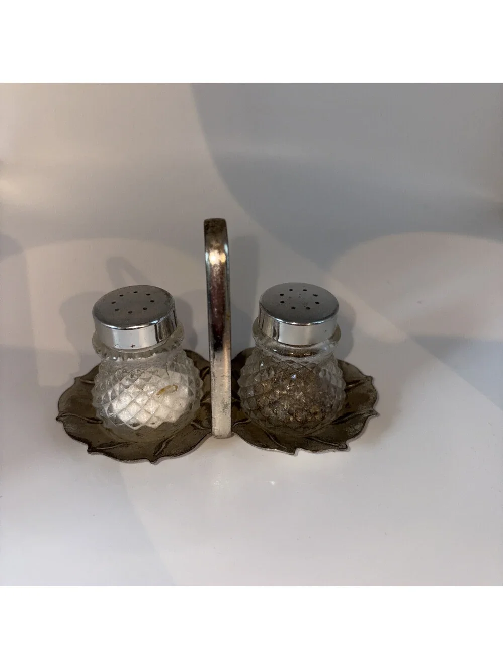 Miniature glass salt and pepper shakers with chrome lids and base holder